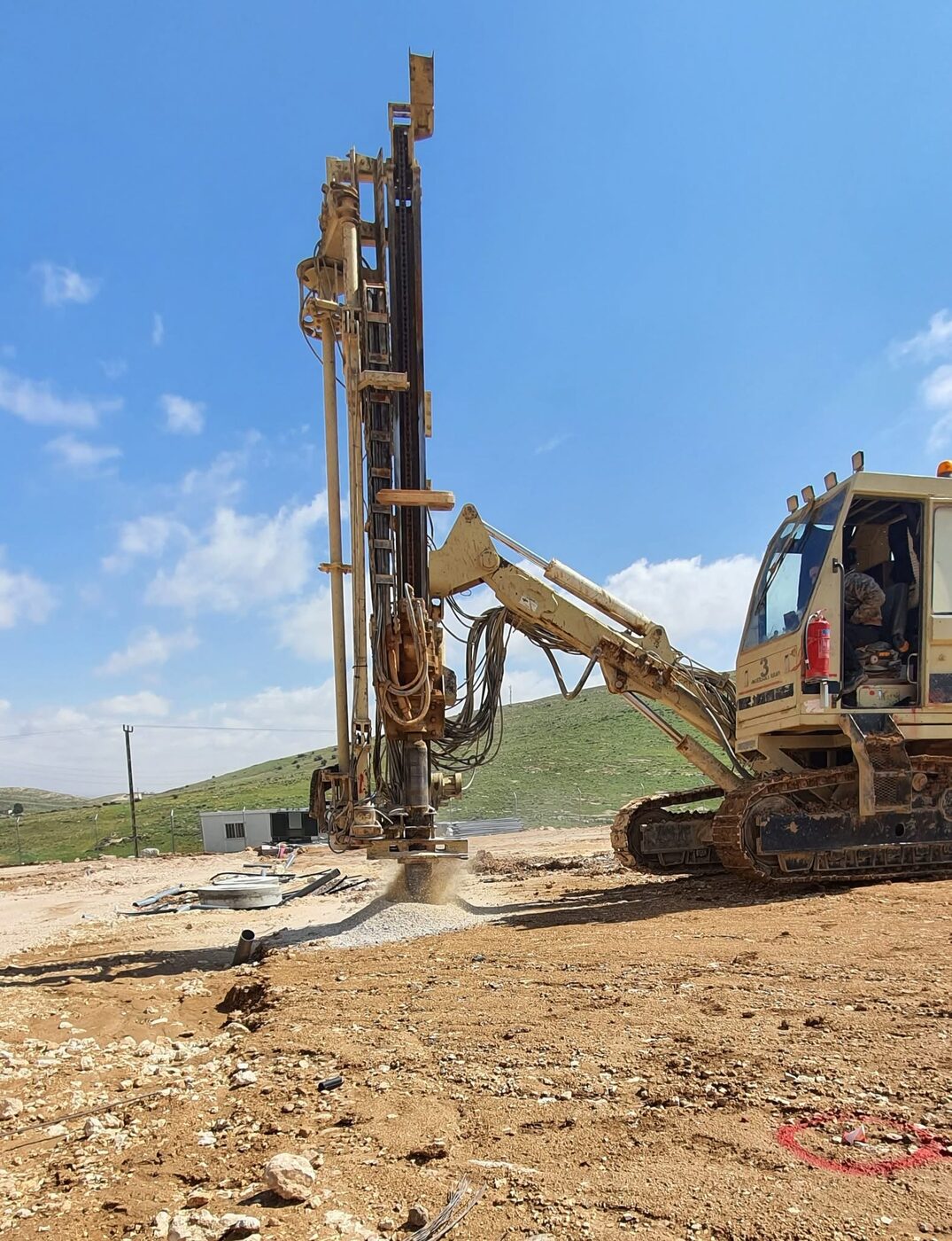 Drilling rig setting foundation for solar system structure